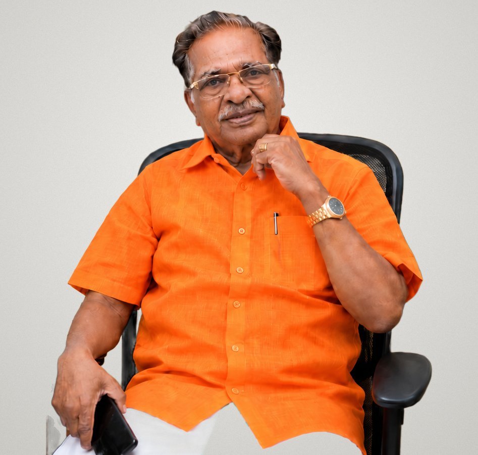 Dr. M. Christopher in an orange shirt