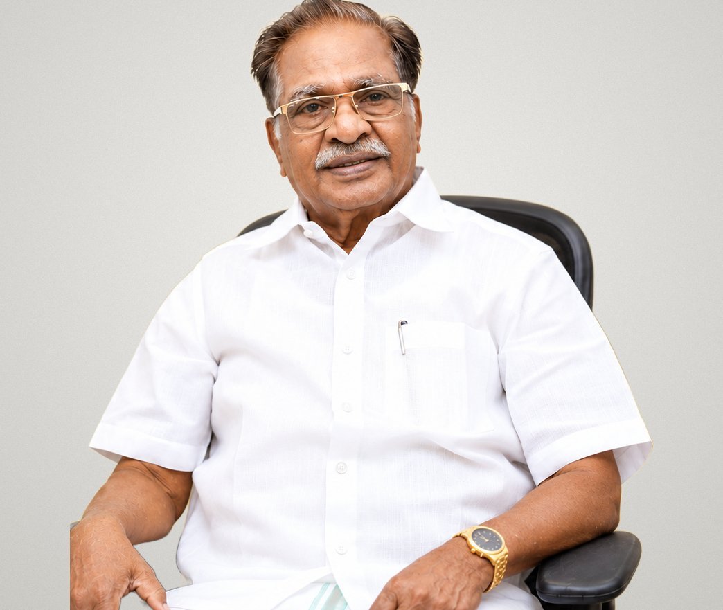 Dr. M. Christopher seated, smiling warmly
